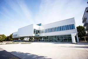 KTU „M-Lab“ pastatas – šiuolaikiškas mokslinių tyrimų ir inovacijų centras Kauno technologijos universiteto miestelyje. Fotografuota dieną, šviesiame fone. Pastatas simbolizuoja MVG centro siekį jungti mokslą, kūrybą ir technologijas.